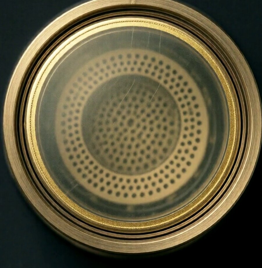 Capsule de micro statique vue de face avec sa membrane dorée tendue devant la plaque fixe percée de trous